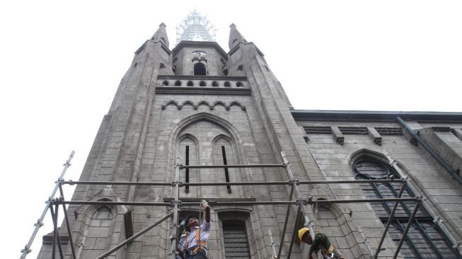 Perbaikan rangka dan pengecatan ulang menara di atap Gereja Katedral.