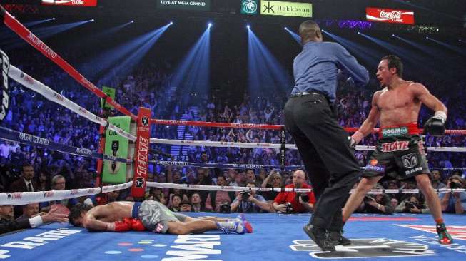 Manny Pacquiao tersungkur di kanvas usai mendapat pukulan telak dari Juan Manuel Marquez (kanan) dalam pertarungan di MGM Grand, Las Vegas, AS, 8 Desember 2012. [AFP/John Gurzinski]