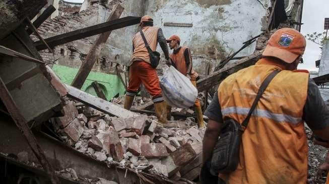 Petugas mengevakuasi puing-puing reruntuhan bangunan di SMPN 32 Jalan Pejagalan Raya No. 51, Pekojan, Jakarta, Kamis (21/12).