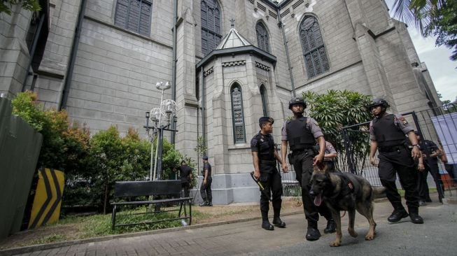 Personel Gegana dan anjing pelajak Mabes Polri melakukan penyisiran dalam operasi sterilisasi Gereja Katedral, di Jakarta, Minggu (24/12/2017).