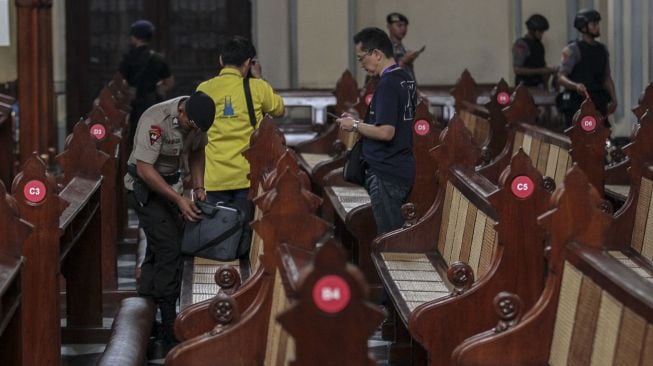 Personel Gegana dan anjing pelajak Mabes Polri melakukan penyisiran dalam operasi sterilisasi Gereja Katedral, di Jakarta, Minggu (24/12/2017).