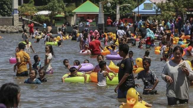 Warga memadati kawasan wisata Pantai Ancol, Jakarta, Senin (25/12).