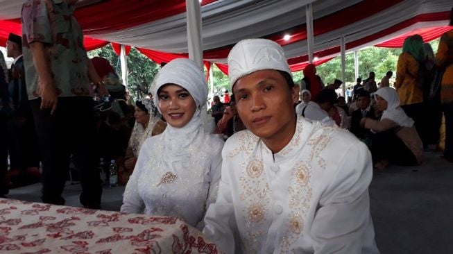 Pasangan Andri dan Nurlaila di pernikahan massal malam Tahun Baru. [Suara.com/Dwi Bowo Rahardjo]