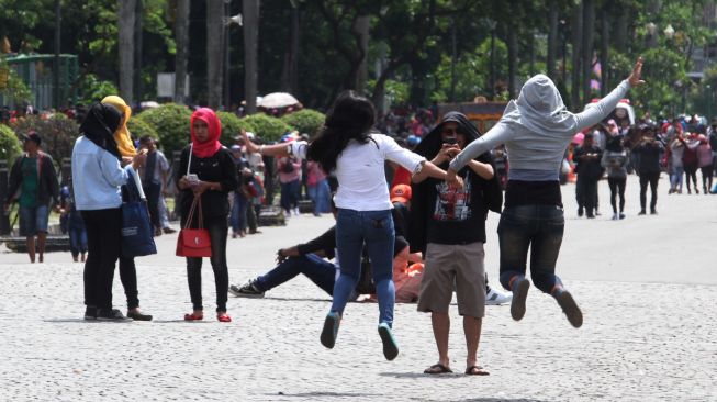Warga manfaatkan libur Tahun Baru 2018 di Monumen Nasional (Monas), Jakarta, Senin (1/1). 