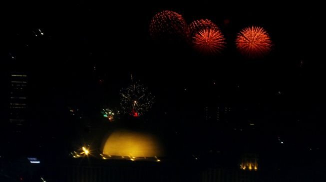 Kembang api menghiasi kemeriahan malam pergantian tahun baru 2018 di Moumen Nasional (Monas), Jakarta, Senin (1/1/2018) [Suara.com/Oke Atmaja]