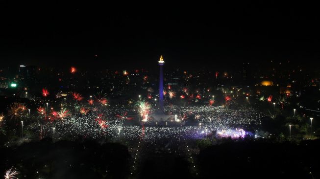 Kembang api menghiasi kemeriahan malam pergantian tahun baru 2018 di Moumen Nasional (Monas), Jakarta, Senin (1/1/2018) [Suara.com/Oke Atmaja]