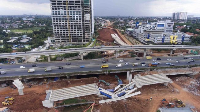 Kendaraan melintas di samping beton girder jalan layang tol Antasari-Depok yang roboh di Jalan Antasari, Jakarta, Selasa (2/1). 