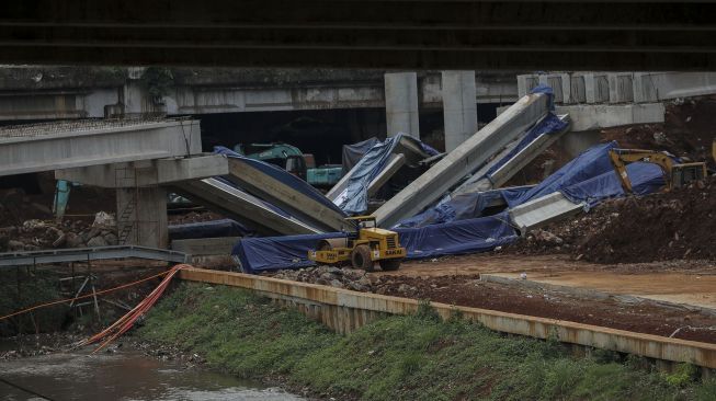 Pekerja dengan menggunakan alat berat melakukan evakuasi girder proyek pembangunan tol Antasari-Depok yang roboh di Jalan Pangeran Antasari, Cilandak, Jakarta, Jumat (5/1). 