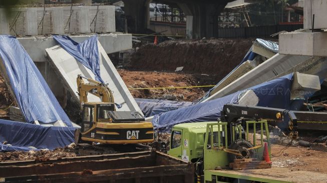 Pekerja dengan menggunakan alat berat melakukan evakuasi girder proyek pembangunan tol Antasari-Depok yang roboh di Jalan Pangeran Antasari, Cilandak, Jakarta, Jumat (5/1). 