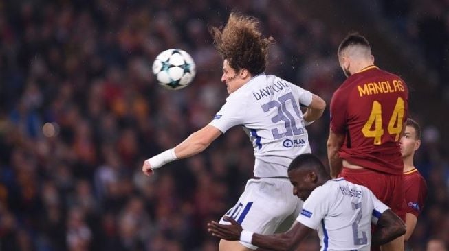 Pemain Chelsea David Luiz (kiri) memenangkan duel di udara saat menghadapi AS Roma [AFP]