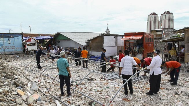 Badan Penanggulangan Bencana Daerah (BPBD) DKI Jakarta membangun satu unit tenda pengungsian di Kampung Akuarium, Kelurahan Penjaringan, Penjaringan, Jakarta, Jumat (5/1). 