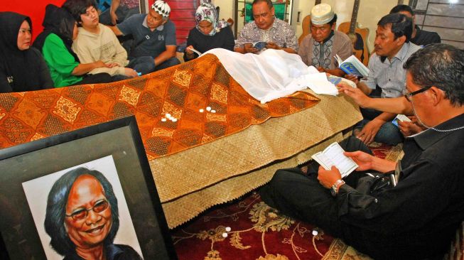 Sejumlah keluarga dan kerabat membacakan Surat Yassin di samping jenazah musisi legendaris Indonesia Yon Koeswoyo di kediamannya di Pamulang, Tangerang Selatan, Banten, Jumat (5/1). 