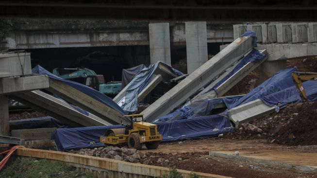 Pekerja dengan menggunakan alat berat melakukan evakuasi girder proyek pembangunan tol Antasari-Depok yang roboh di Jalan Pangeran Antasari, Cilandak, Jakarta, Jumat (5/1). 