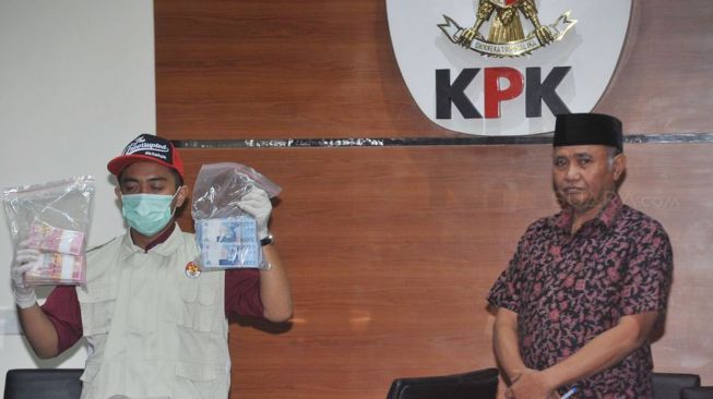 Ketua KPK Agus Rahardjo dan seorang penyidik menunjukkan barang bukti hasil operasi tangkap tangan (OTT) di gedung KPK, Jakarta, Jumat (5/1).