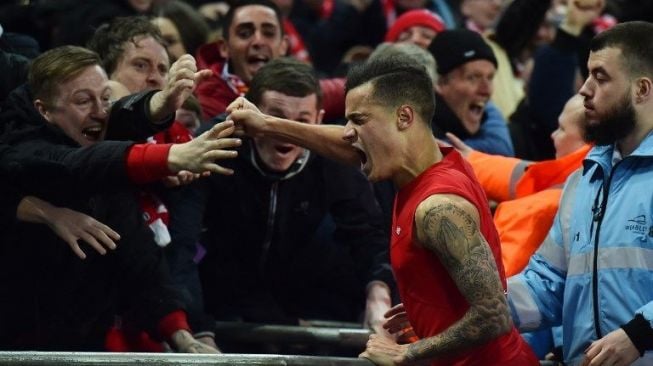 Philippe Coutinho rayakan keberhasilannya mencetak gol bersama fans Liverpool [AFP]