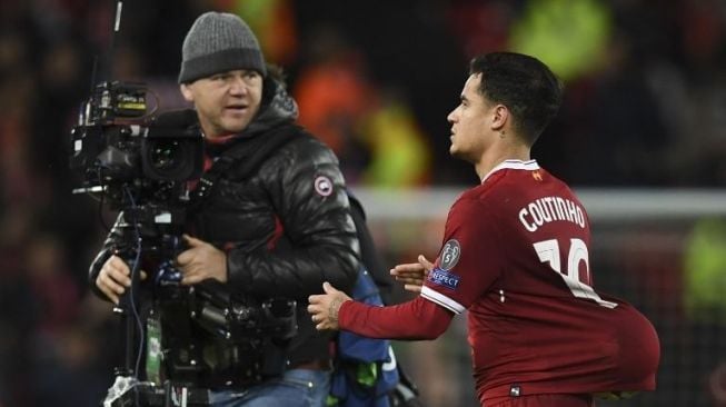 Philippe Coutinho mendekati seorang juru kamera sambil menyembunyikan bola di jersey bagian belakang usai kemenangan Liverpool di pertandingan fase grup Liga Champions [AFP]