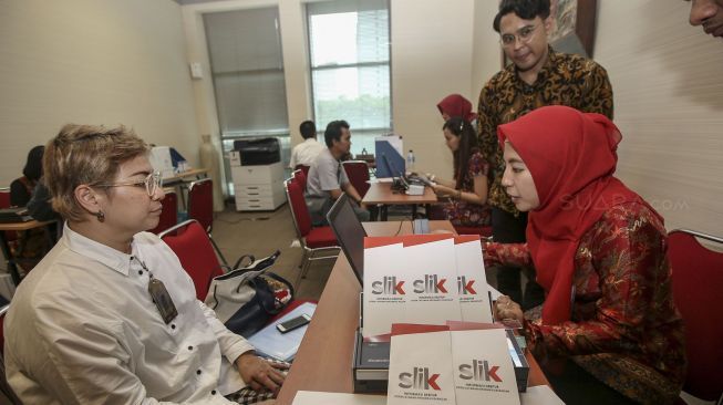 Petugas melayani pemohon Sistem Layanan Informasi Keuangan (SLIK) di kantor Otoritas Jasa Keuangan (OJK), Jakarta, Senin (8/1).