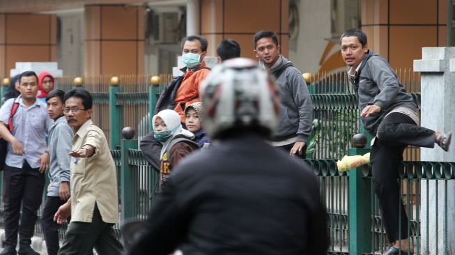 Sejumlah penumpang melompati pagar pembatas di Stasiun Cikini, Jakarta, Senin (8/1). 