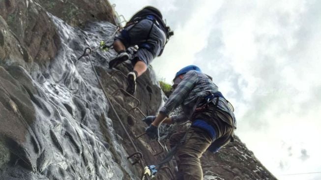 Membutuhkan konsentrasi yang sangat tinggi saat merayapi satu persatu tangga besi menuju Skylodge di Gunung Parang, Purwakarta. (Foto: Suara.com)