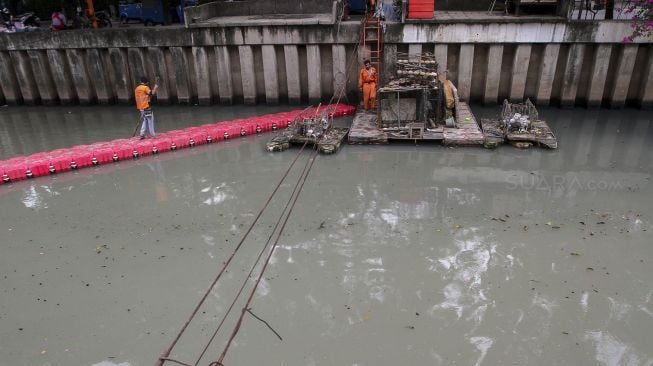 Petugas Penanganan Sarana dan Prasarana Umum (PPSU) DKI Jakarta membersihkan aliran sungai di kawasan Kebon Sirih, Jakarta, Selasa (9/1). 