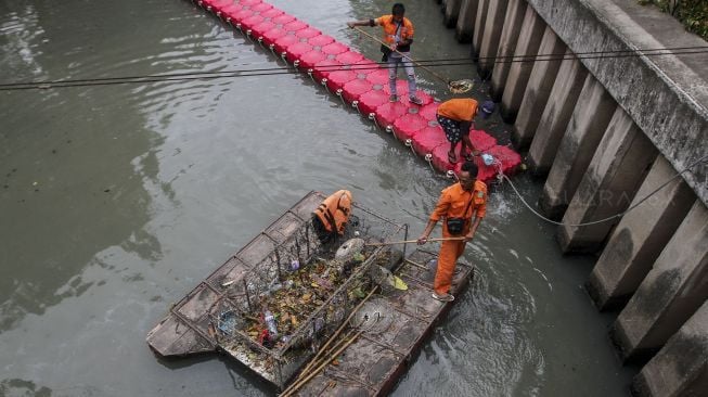 Petugas Penanganan Sarana dan Prasarana Umum (PPSU) DKI Jakarta membersihkan aliran sungai di kawasan Kebon Sirih, Jakarta, Selasa (9/1). 