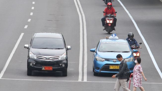 Pengendara sepeda motor melintasi Jalan MH Thamrin, Jakarta, Jumat (12/1).