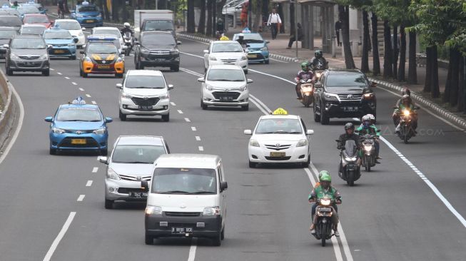 Pengendara sepeda motor melintasi Jalan MH Thamrin, Jakarta, Jumat (12/1).
