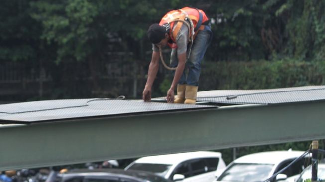 Pekerja menyelesaikan pembangunan jembatan penyeberangan orang (JPO) di Halte Kuningan Timur, Jakarta Selatan, Sabtu (13/1).