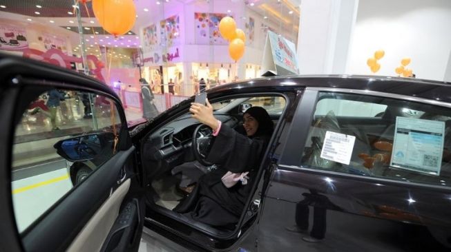 Seorang perempuan Arab Saudi sedang memotret dirinya sendiri dalam sebuah pameran mobil di Jedah, pada Kamis (11/1)/ [AFP/Amer Hilabi]