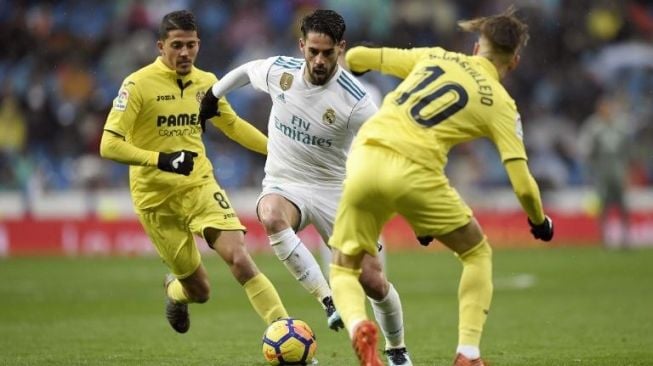 Pemain Madrid Isco mencoba melewati dua pemain Villarreal [AFP]