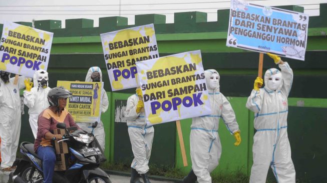 Sejumlah aktivis lingkungan hidup yang tergabung dalam Ecoton membentangkan poster ketika menggelar aksi 'jangan buang popok di Jembatan Sepanjang', Surabaya, Jawa Timur, Selasa (16/1).