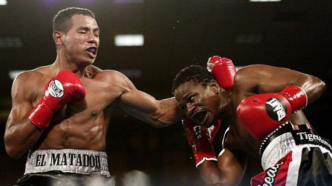 Ricardo Mayorga (kiri) melayangkan pukulan ke wajah Vernon Forrest, (25/1/2003). [AFP/Jeff Haynes]