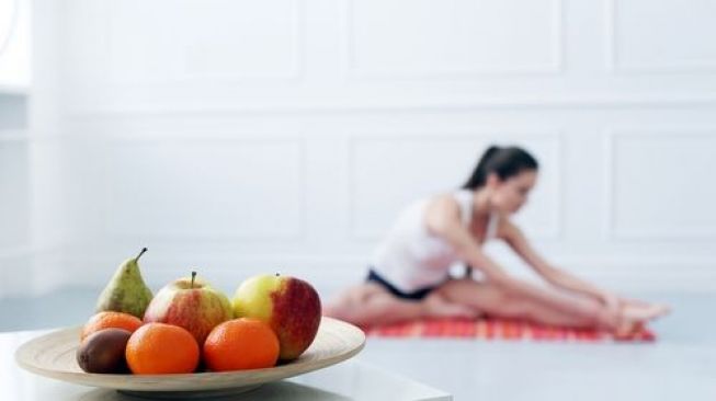 Seorang perempuan sedang latihan fisik ( olahraga ) sebelum sarapan buah. (Shutterstock)