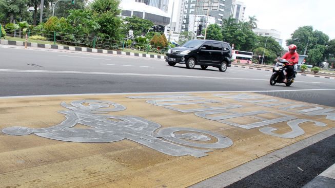 Roda dua yang tidak melintas di jalur khusus dikenakan tilang oleh polisi. 