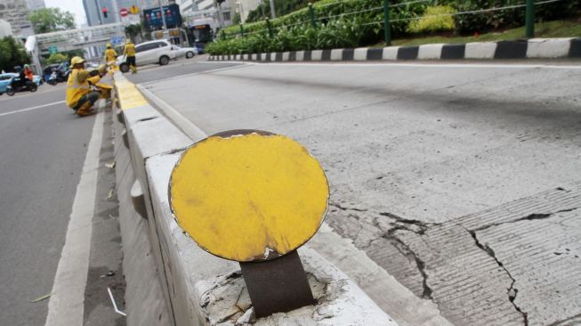 Petugas Dinas Bina Marga DKI Jakarta mengecat Movable Concrete Barrier (MCB) di jalur Transjakarta di kawasan Jalan MH Thamrin, Jakarta, Sabtu (20/1). 