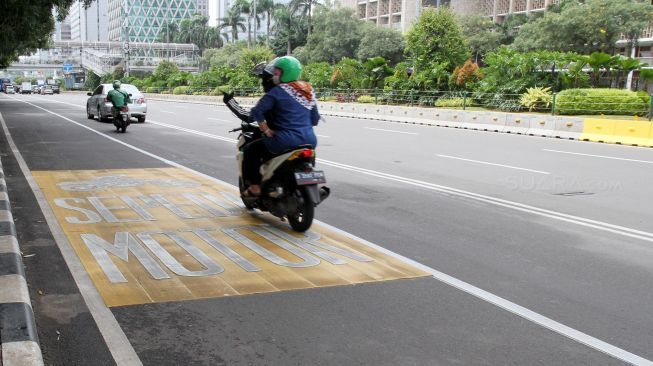 Sepeda motor melintas di Jalan MH Thamrin, Jakarta, Sabtu (20/1). 