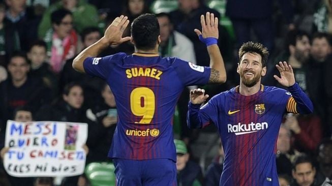 Penyerang Barcelona, Lionel Messi, merayakan golnya ke gawang Real Betis dengan rekan setimnya, Luis Suarez, Minggu (21/1/2018). [AFP/Cristina Quicler]