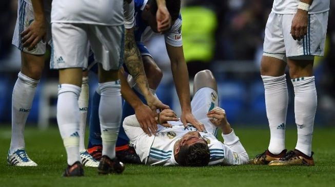 Pemain Real Madrid Cristiano Ronaldo terbaring kesakitan setelah darah mengucur dari wajahnya [AFP]