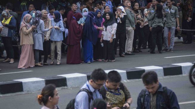 Sejumlah karyawan Komisi Pemberantasan Korupsi (KPK) berkumpul di luar gedung pasca gempa yang mengguncang di kawasan Kuningan, Jakarta, Selasa (23/1). 
