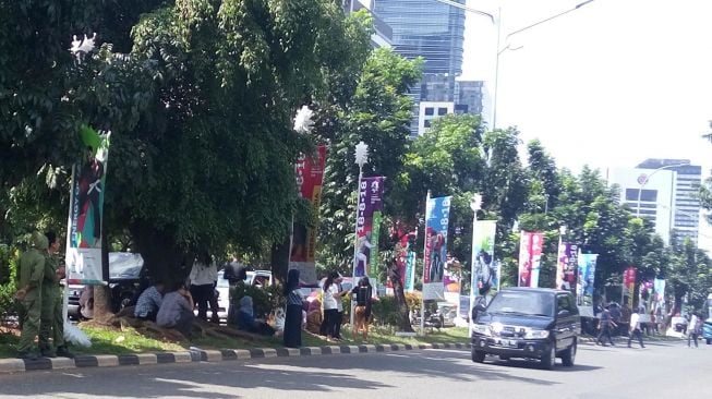 Sejumlah pekerja dari sekitar kawasan Sudirman, Jakarta Pusat berkumpul di pinggir jalan setelah ibu kota diguncang gempa berkekuatan 6,1SR pada Selasa (23/1). [Suara.com/Liberty Jemadu]