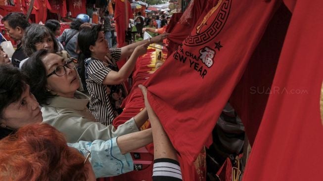 Pengunjung memilih pernak pernik imlek di kawasan Glodok, Jakarta, Selasa (23/1).