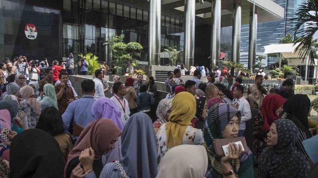 Sejumlah karyawan Komisi Pemberantasan Korupsi (KPK) berkumpul di luar gedung pasca gempa yang mengguncang di kawasan Kuningan, Jakarta, Selasa (23/1). 