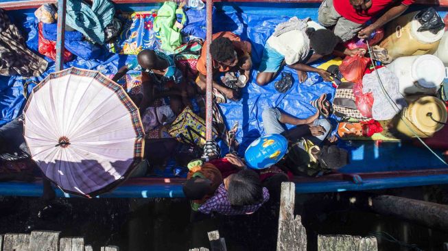 Warga dan anak-anak pasien gizi buruk dan campak usai menjalani pemeriksaan dan perawatan kesehatan di RSUD Agats, menuju Distrik Jetsy di Kabupaten Asmat, Papua, Selasa (23/1). 