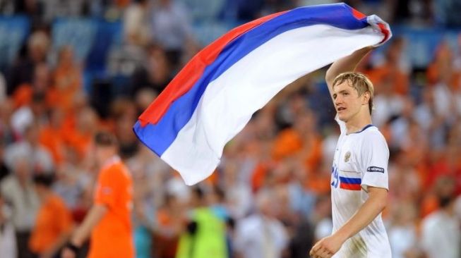 Roman Pavlyuchenko mengibarkan bendara Rusia usai Timnas Rusia menang atas Belanda di perempat final Piala Eropa 2008. [AFP/Patrick Hertzog]