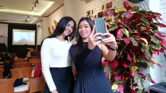 Dua orang model sedang berswafoto menggunakan ponsel Infinix Zero 5 di Jakarta, Kamis (25/1). [Suara.com/Aditya Gema Pratomo]