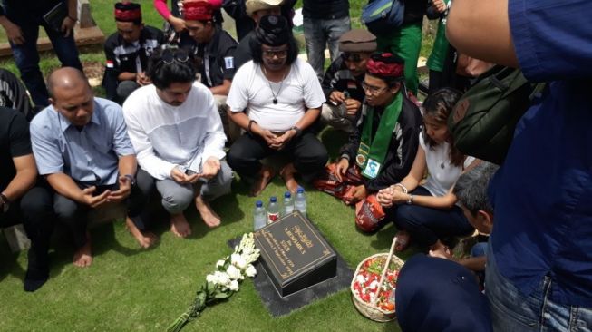 Reza Rahadian menziarahi makam Benyamin Sueb. (Ismail/Suara.com)