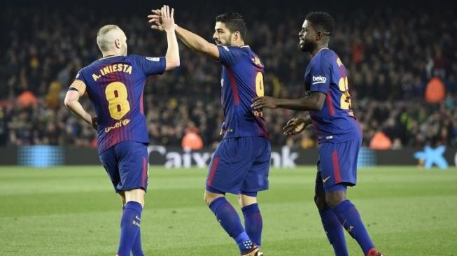 Luis Suarez (tengah) merayakan golnya ke gawang Espanyol bersama kedua rekannya di Barcelona, Andres Iniesta (kiri) dan Samuel Umtiti di Camp Nou, Kamis (25/1/2018). [AFP/Lluis Gene]