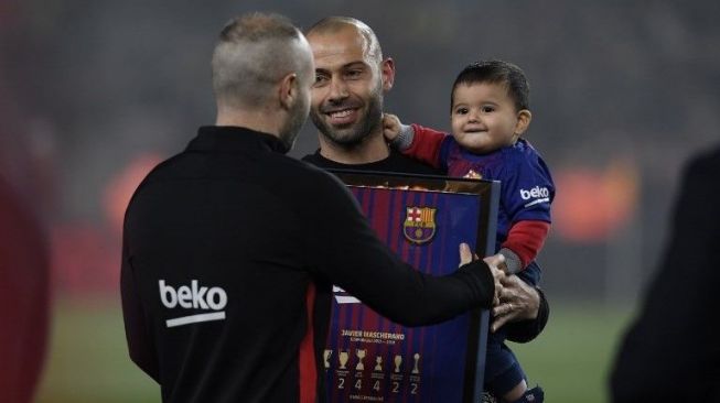 Kapten Barcelona Andres Iniesta memberikan bingkai atas pencapaian Javier Mascherano dengan Barcelona. LLUIS GENE / AFP