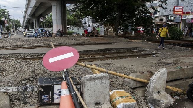 Perlintasan kereta api tanpa pintu dan tanda bahaya di kawasan Bandengan, Jakarta, Jumat (26/1). 