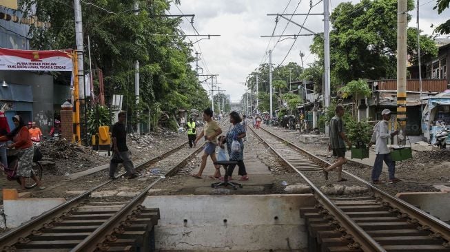 Perlintasan kereta api tanpa pintu dan tanda bahaya di kawasan Bandengan, Jakarta, Jumat (26/1). 